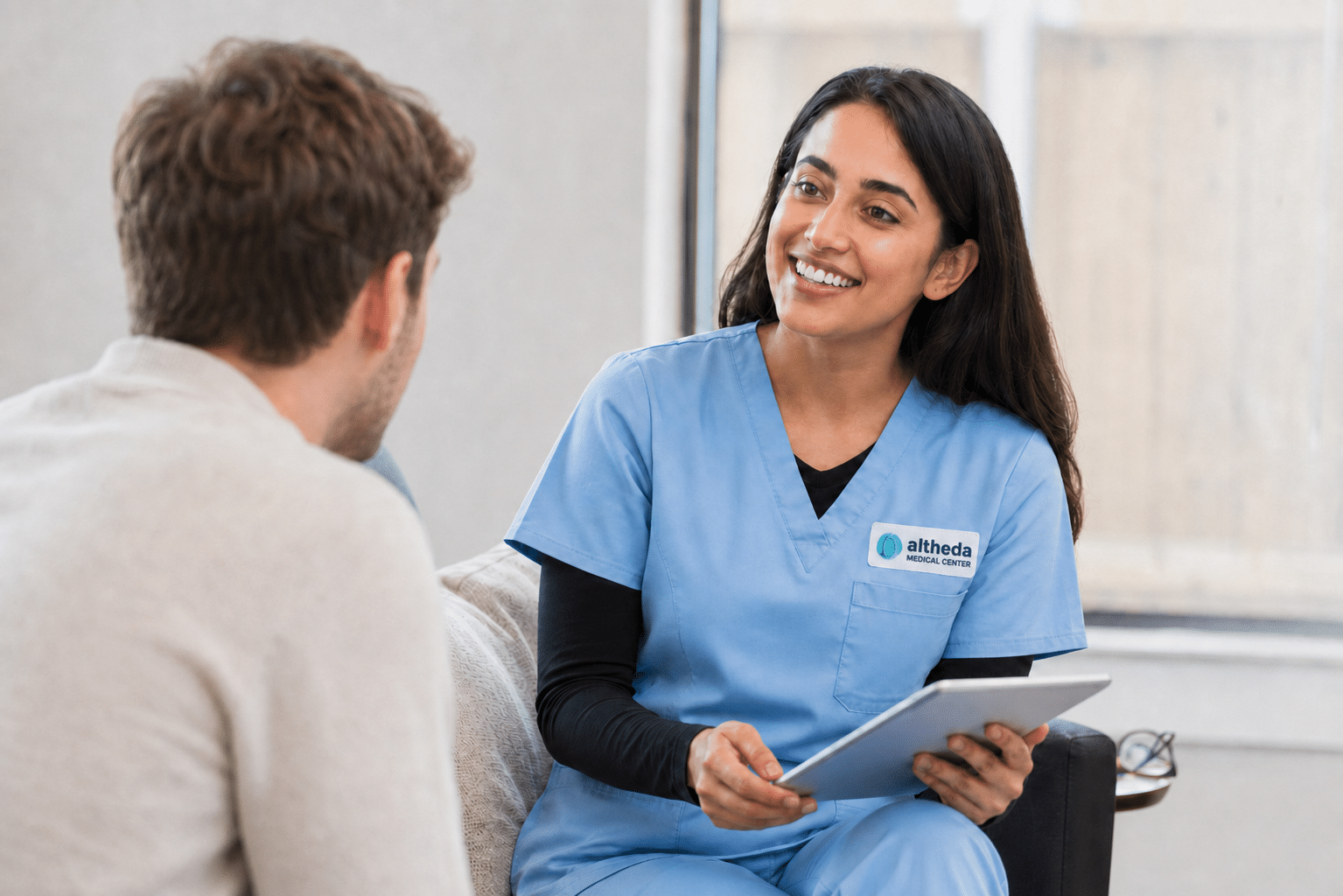 Clinical image for Altheda Medical Center's high cholesterol management page in Pittsburgh showing provider reviewing cholesterol lab results with adult patient.